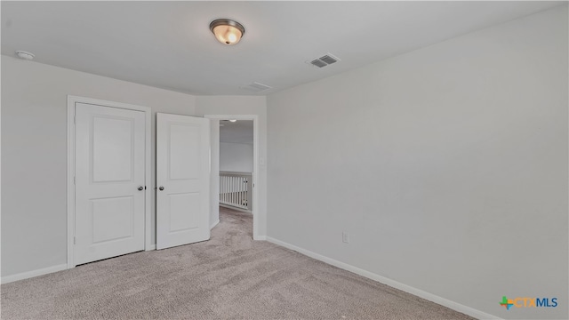 unfurnished bedroom featuring light carpet