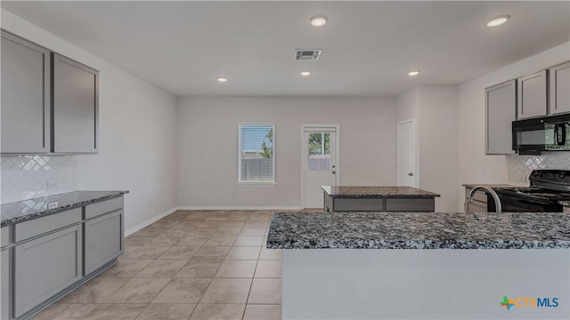 300 Jacks Pl, Seguin, TX 78155 - kitchen featuring black appliances, tasteful backsplash, dark stone counters, gray cabinetry, and a kitchen island