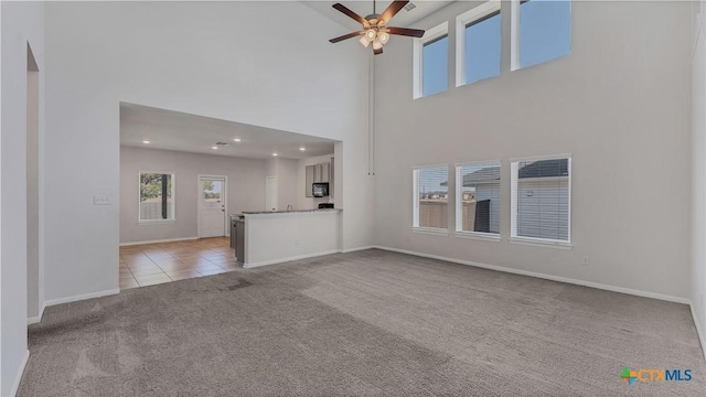 300 Jacks Pl, Seguin, TX 78155 - unfurnished living room with light carpet, a ceiling fan, baseboards, a towering ceiling, and recessed lighting