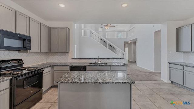 300 Jacks Pl, Seguin, TX 78155 - kitchen with black appliances, gray cabinetry, a sink, a ceiling fan, and dark stone counters