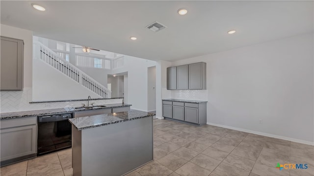 kitchen with a kitchen island, stone countertops, sink, decorative backsplash, and dishwasher