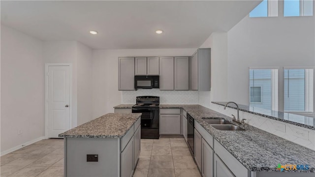 300 Jacks Pl, Seguin, TX 78155 - kitchen featuring black appliances, gray cabinetry, a sink, dark stone counters, and decorative backsplash