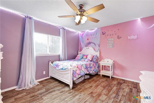 bedroom with hardwood / wood-style flooring, a textured ceiling, and ceiling fan