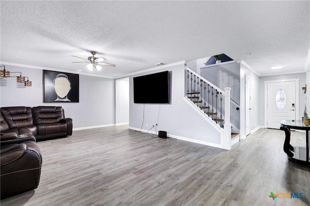 living room with crown molding, hardwood / wood-style floors, ceiling fan, and a textured ceiling