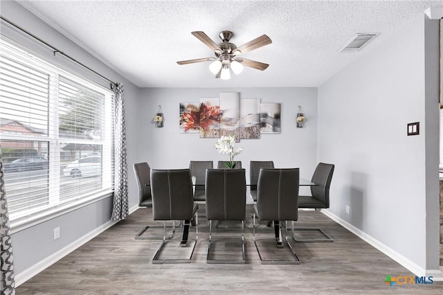 dining room with ceiling fan, dark hardwood / wood-style floors, and a textured ceiling