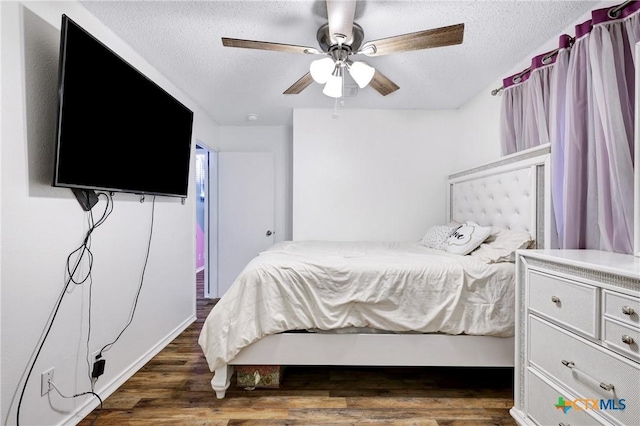 bedroom with a textured ceiling, dark wood-type flooring, and ceiling fan