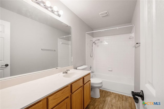 full bath with visible vents, toilet, shower / bathtub combination, wood finished floors, and vanity