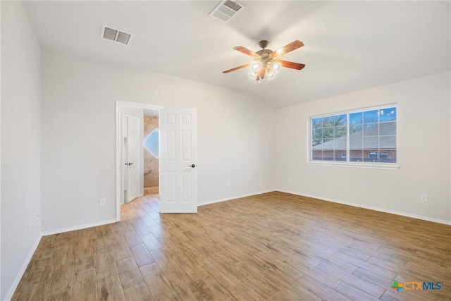 spare room featuring visible vents, wood finished floors, and a ceiling fan