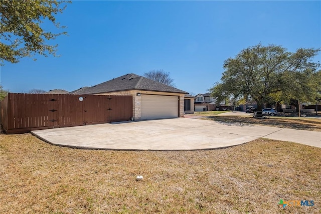 view of side of property with a garage, a yard, and driveway