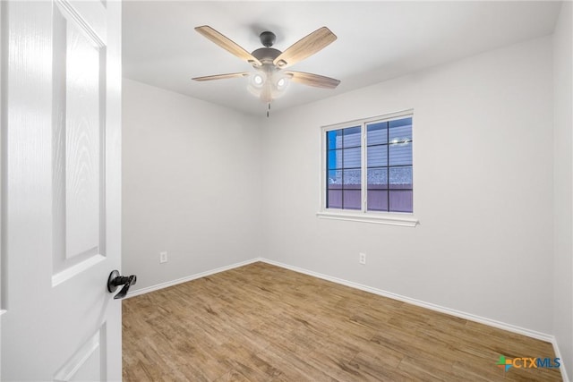 spare room with a ceiling fan, baseboards, and wood finished floors