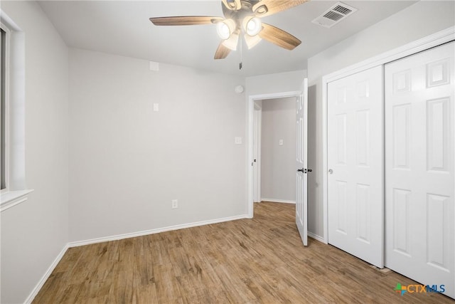 unfurnished bedroom with light wood-style floors, visible vents, a closet, and baseboards