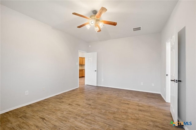 unfurnished room with visible vents, light wood-style flooring, baseboards, and ceiling fan