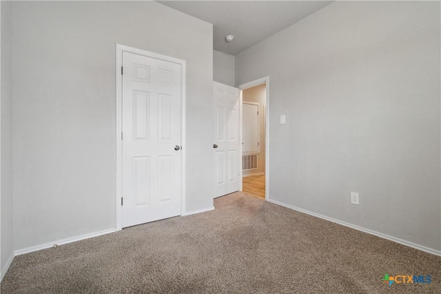 unfurnished bedroom featuring carpet floors, baseboards, and visible vents