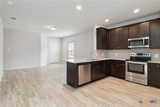 kitchen with visible vents, decorative backsplash, dark brown cabinetry, a sink, and stainless steel appliances