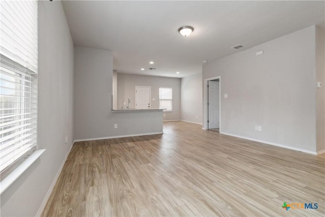 unfurnished living room with recessed lighting, baseboards, visible vents, and light wood-style floors