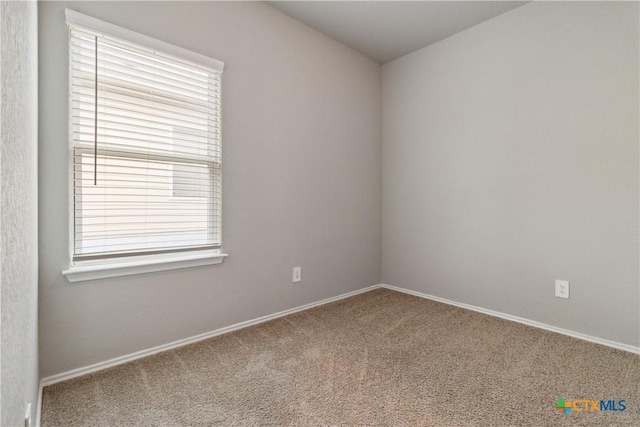 carpeted spare room with baseboards