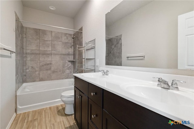 full bath with a sink, double vanity, toilet, shower / bath combination, and wood finished floors