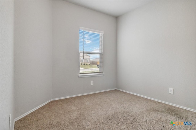 carpeted spare room with baseboards