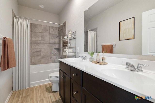 bathroom featuring a sink, shower / bath combo, toilet, and wood finished floors