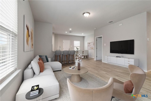living area featuring recessed lighting, baseboards, light wood-type flooring, and visible vents