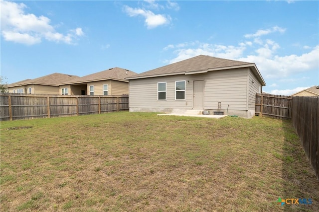 rear view of property with a lawn, a fenced backyard, and a patio area