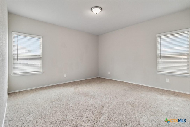 empty room with baseboards and carpet
