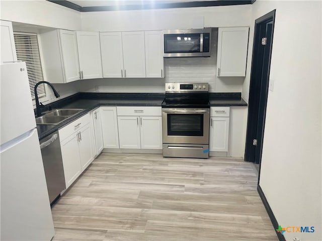 1218 Paseo Del Cobre, Temple, TX 76502 - kitchen featuring stainless steel appliances, white cabinets, light wood finished floors, and dark countertops