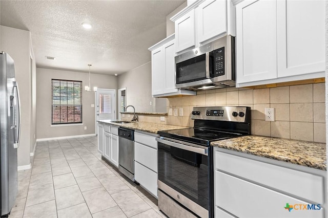 1536 Justice Dr, Copperas Cove, TX 76522 - kitchen featuring appliances with stainless steel finishes, decorative backsplash, white cabinets, a textured ceiling, and light stone counters