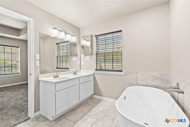 1536 Justice Dr, Copperas Cove, TX 76522 - bathroom with a freestanding bath, double vanity, and a textured ceiling