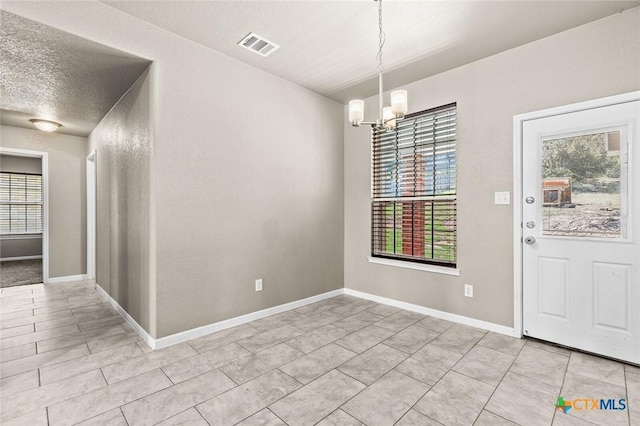 1536 Justice Dr, Copperas Cove, TX 76522 - unfurnished dining area featuring a chandelier, plenty of natural light, a textured ceiling, and light tile patterned flooring