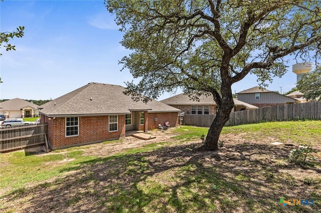 1536 Justice Dr, Copperas Cove, TX 76522 - back of house with a fenced backyard, brick siding, and a shingled roof