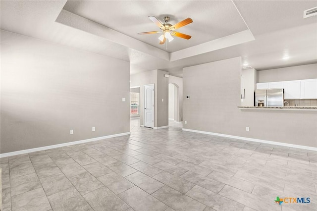 1536 Justice Dr, Copperas Cove, TX 76522 - unfurnished living room with a raised ceiling, ceiling fan, and arched walkways