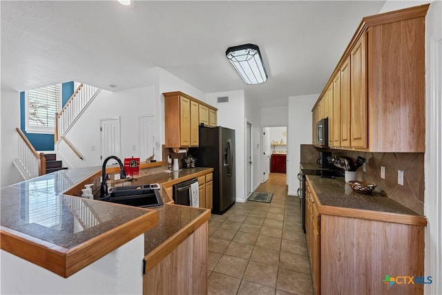 kitchen featuring sink, backsplash, black appliances, light tile patterned flooring, and kitchen peninsula