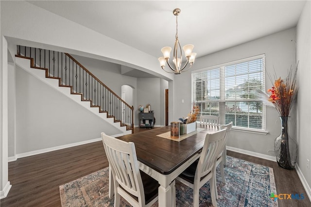 dining room with dark hardwood / wood-style floors and a notable chandelier