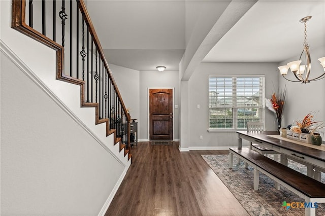 entrance foyer with dark hardwood / wood-style flooring and a notable chandelier