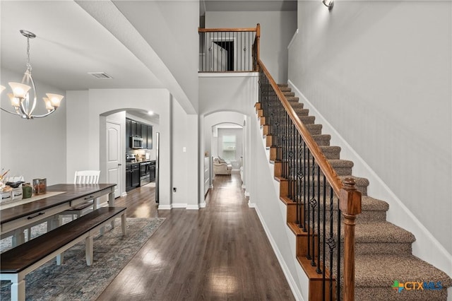 entryway featuring an inviting chandelier, a high ceiling, and dark hardwood / wood-style floors