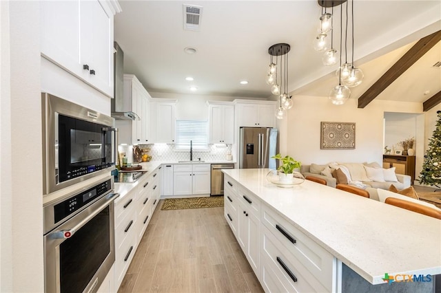 1428 Springwater, Canyon Lake, TX 78133 - kitchen with stainless steel appliances, wall chimney range hood, beamed ceiling, white cabinetry, and backsplash