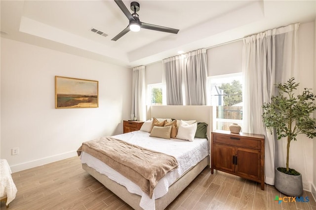 1428 Springwater, Canyon Lake, TX 78133 - bedroom featuring a raised ceiling, light wood-style floors, and a ceiling fan