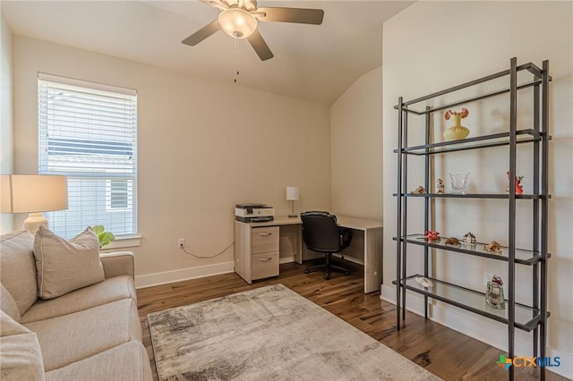 home office with a ceiling fan, vaulted ceiling, wood finished floors, and baseboards