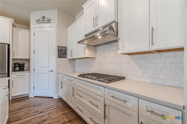 kitchen featuring under cabinet range hood, appliances with stainless steel finishes, light wood-style flooring, and white cabinetry