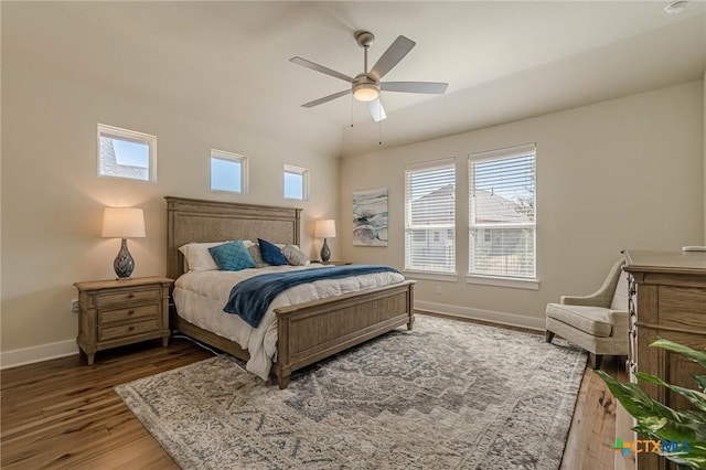 bedroom with a ceiling fan, lofted ceiling, wood finished floors, and baseboards