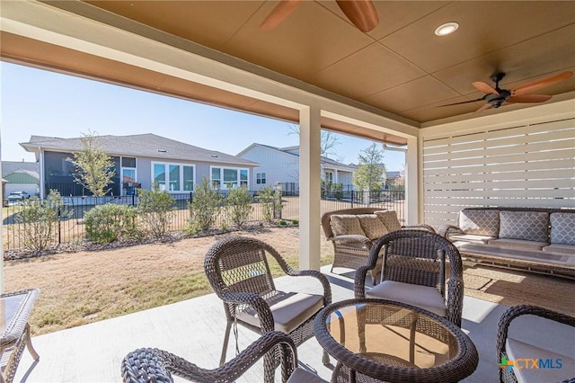 view of patio / terrace with a ceiling fan, fence, and a residential view