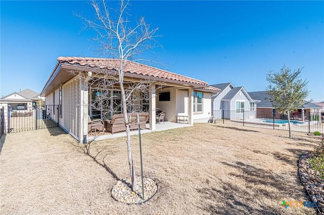 rear view of property with a tiled roof, fence, stucco siding, and a patio area