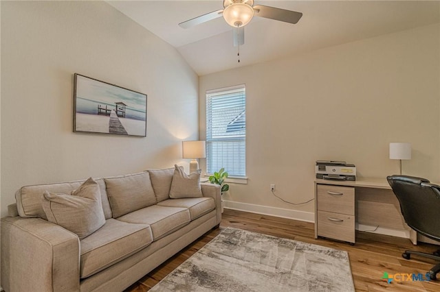 office space featuring ceiling fan, baseboards, wood finished floors, and vaulted ceiling