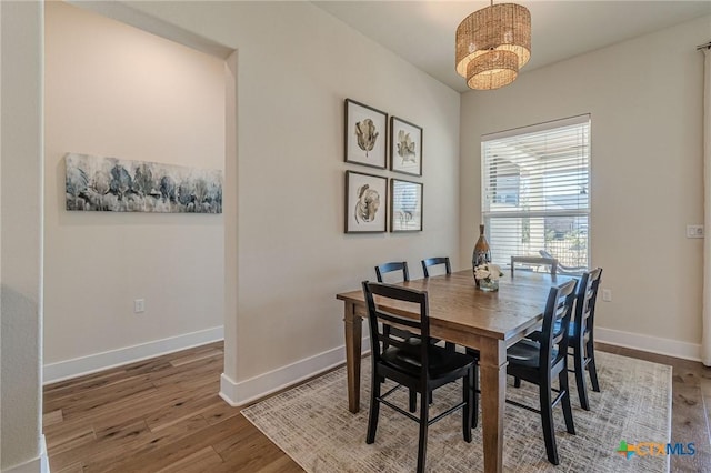 dining area with baseboards and wood finished floors