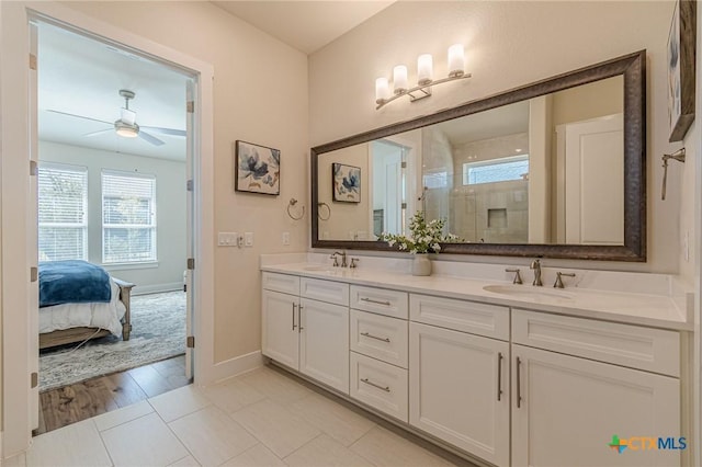 bathroom with a sink, a stall shower, double vanity, and ceiling fan