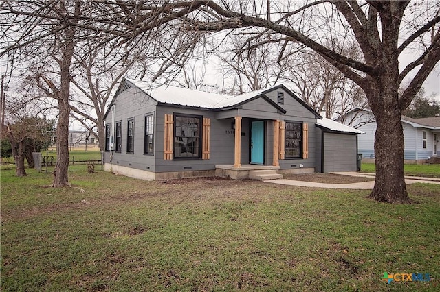 view of front of property with a front yard, crawl space, metal roof, and driveway