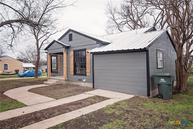 view of front of home with crawl space, an attached garage, and metal roof