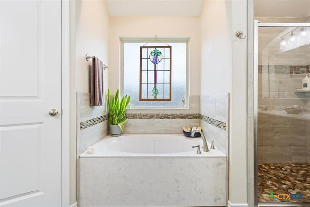 bathroom featuring shower with separate bathtub