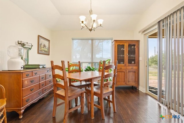 dining area featuring dark hardwood / wood-style floors, vaulted ceiling, and a chandelier